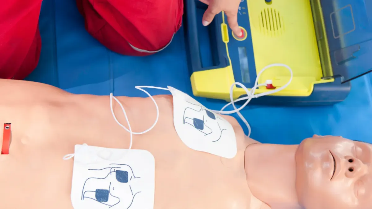 Defibrillator training dummy on floor.