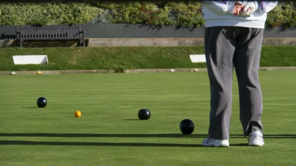 Bowling green with balls and umpire standing